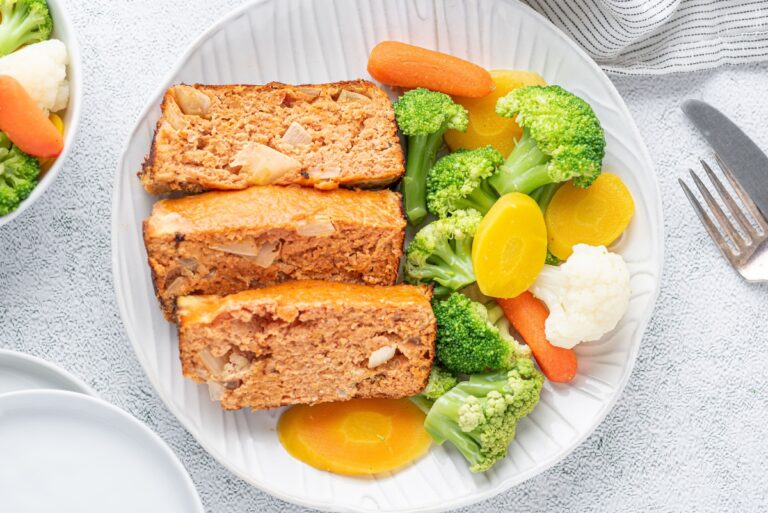 Sliced pieces of chicken meatloaf served on the plate with veggies
