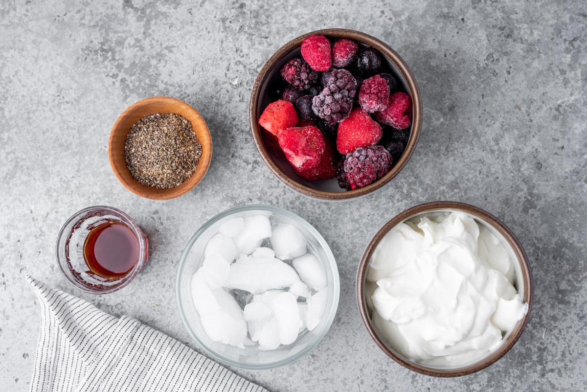 Bowl of ice, strawberries, chia seeds, Greek yogurt and shot of vanilla extract
