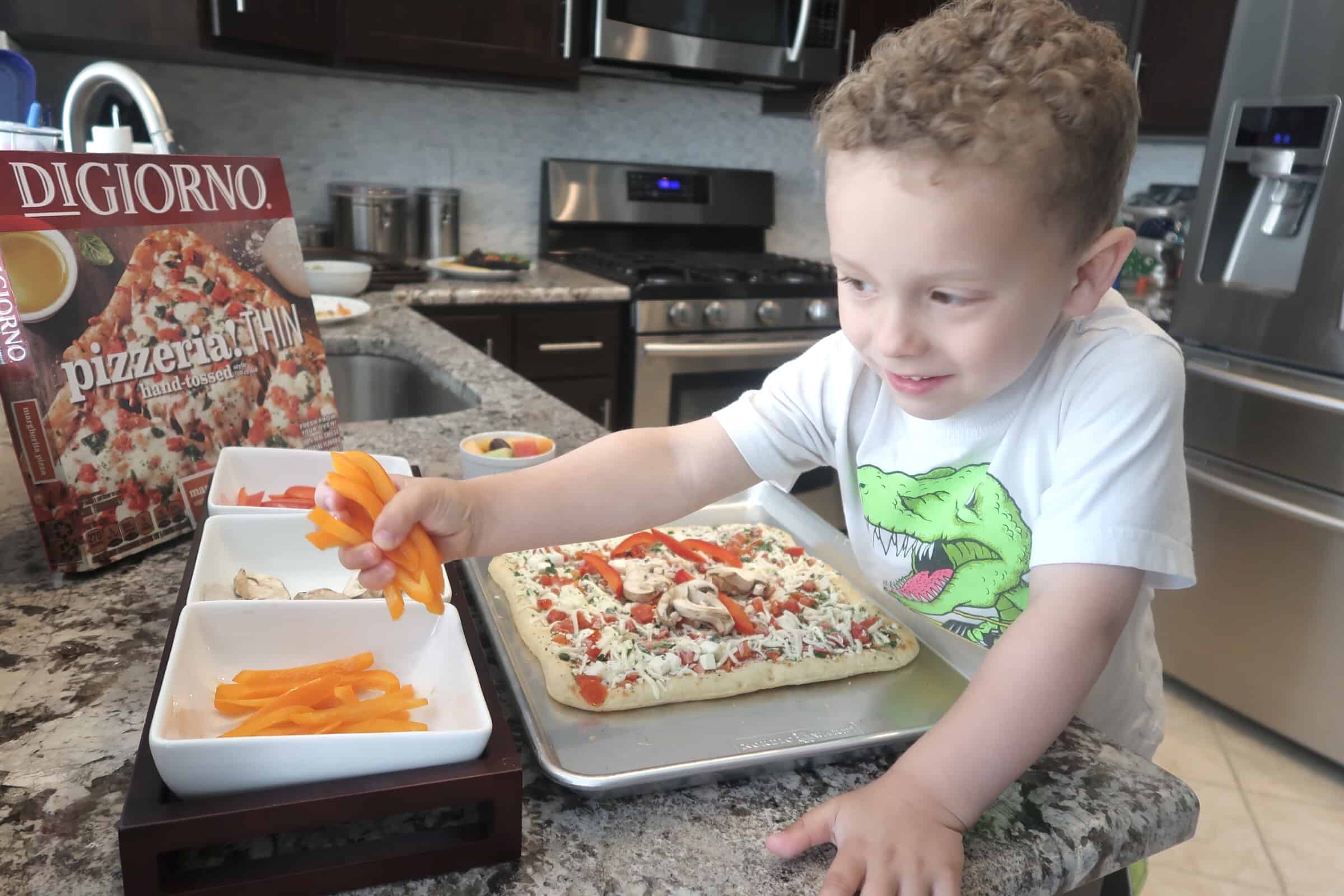 child adds vegetables to pizza