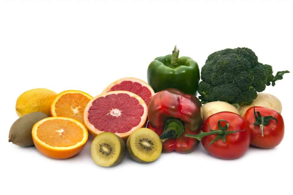 Foods rich in Vitamin C. Includes broccoli, potatoes, tomatoes, bell peppers, grapefruit, kiwi fruit, oranges and lemons.