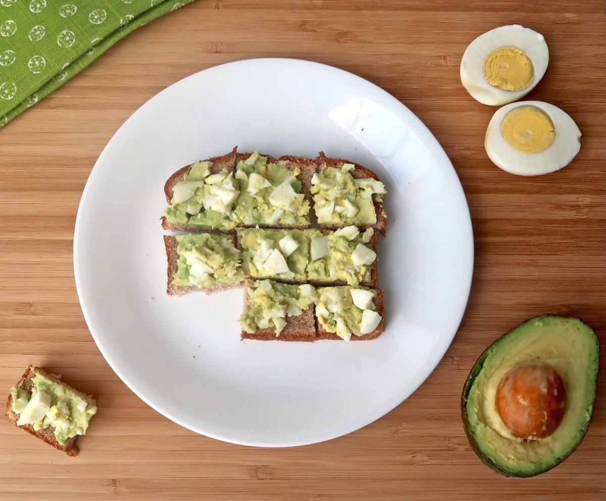 Avocado egg salad spread over toast that has been sliced into nine small squares with one square removed