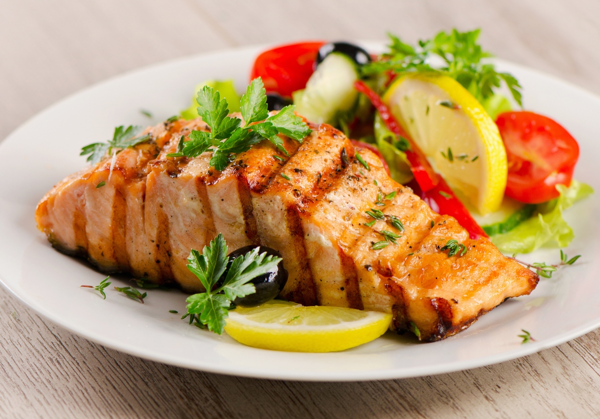 Grilled Salmon with fresh salad and lemon on a plate