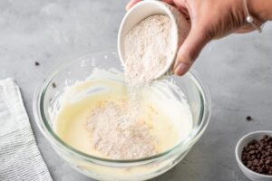 Mixing Greek yogurt and flour in bowl to make pancakes