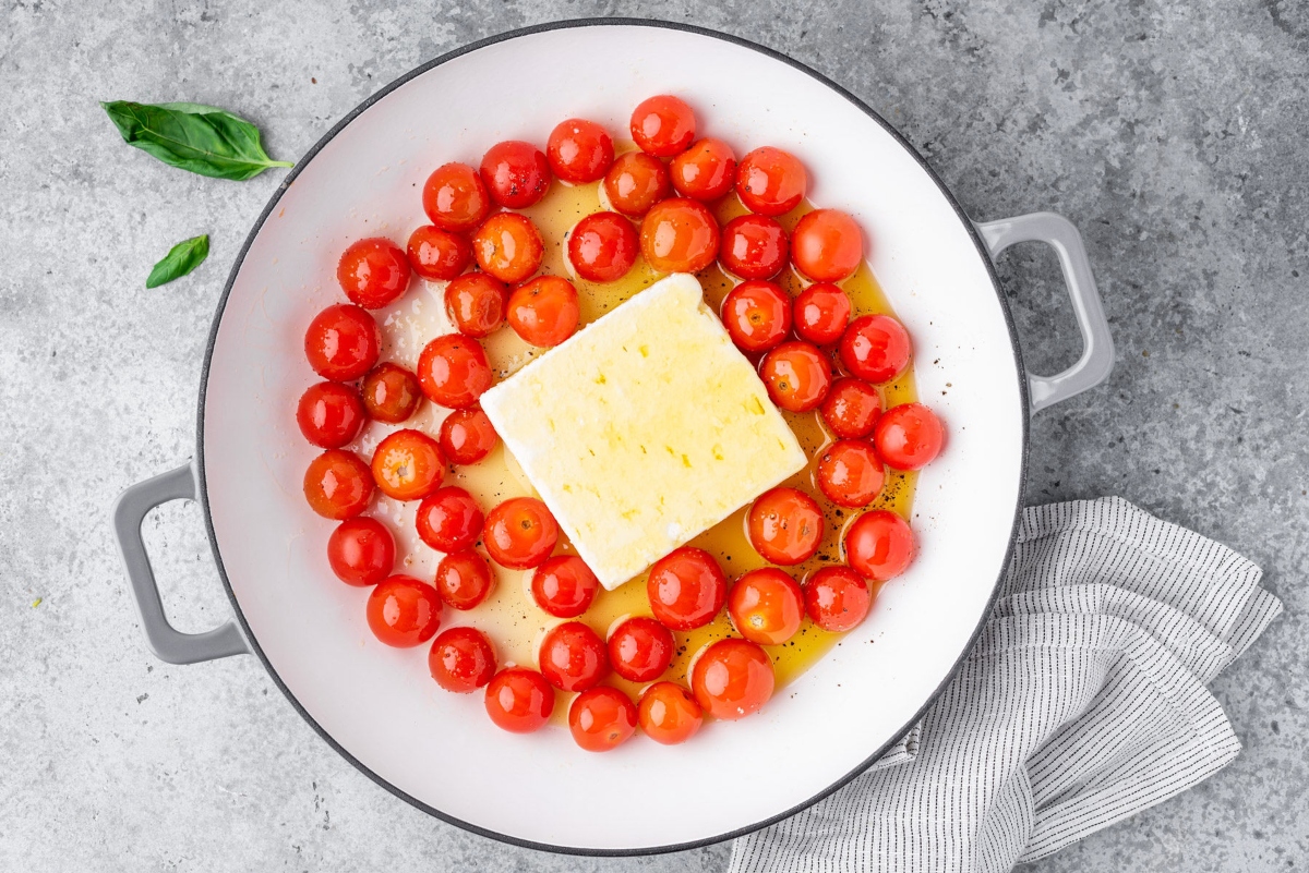 Cooking pot with cherry tomatoes, feta cheese and olive oil 