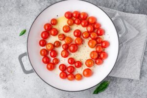 Cooking pan filled with cherry tomatoes and olive oil