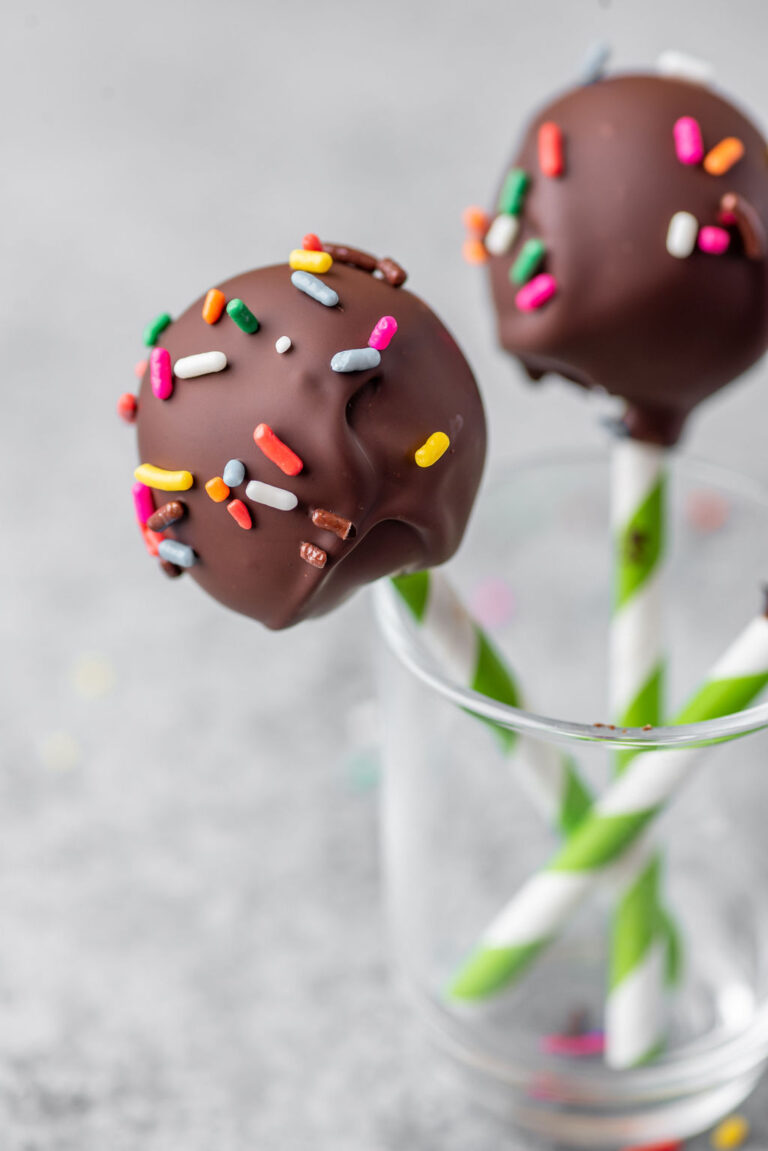 up close shot of a chocolate covered cake pop in a glass jar