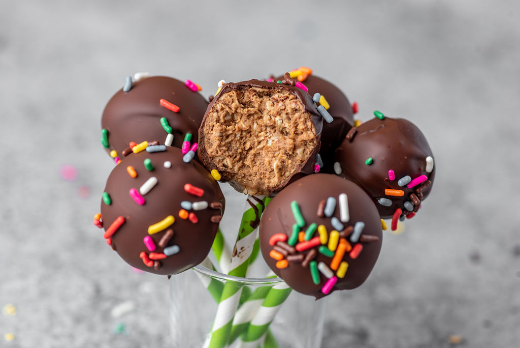 6 chocolate covered cake pops with sprinkles in glass jar