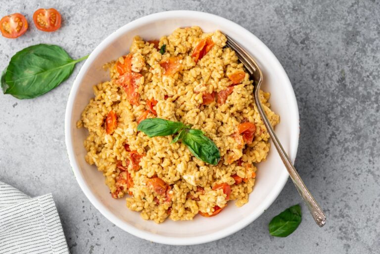 Low Carb Baked Feta Rice in Bowl with a Fork and Basil on Top