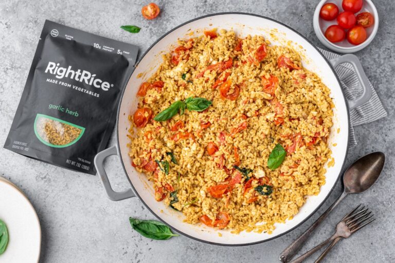 Cooking pen filled with baked feta rice and bag of RightRice, fork and basil around it
