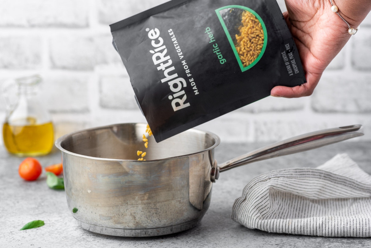 Hand pouring rice from RighRice pack into the sauce pen