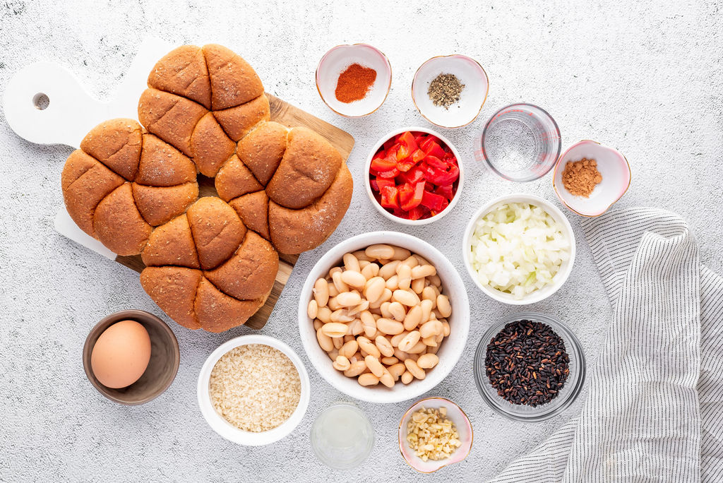 small bowls with various ingredients for bean burger recipe and a plate of buns