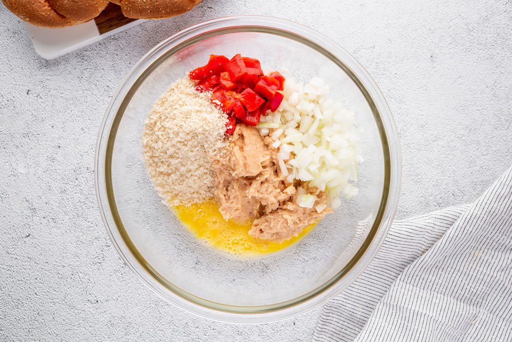 white bean puree with chopped onion, bread crumbs, egg, and roasted red pepper in a glass bowl