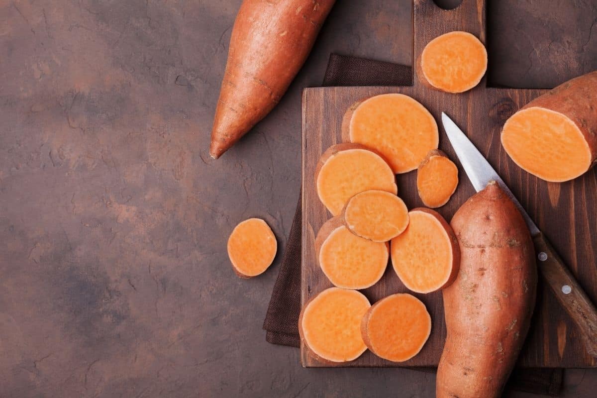 Raw sweet potatoes on a cutting board