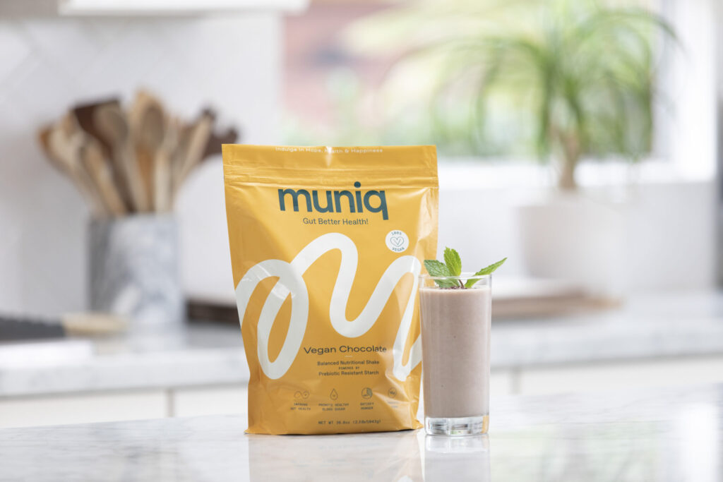 bag of muniq shakes with prepared chocolate shake in clear glass
