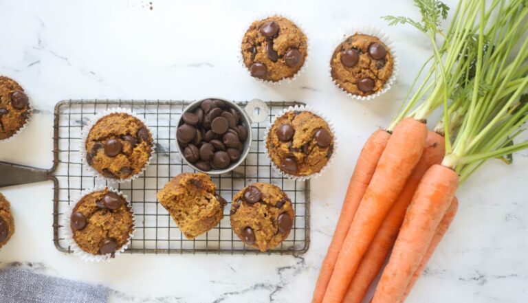 Banana Carrot Muffins with chocolate chips in a bowl and carrots beside them
