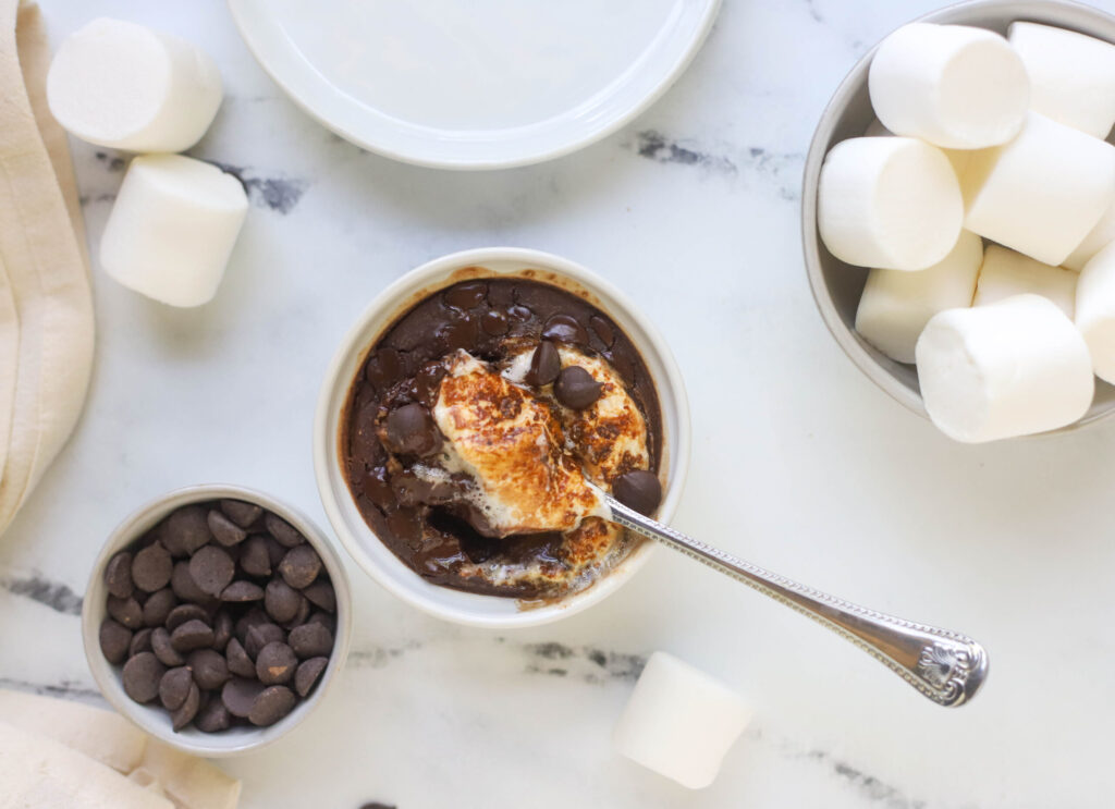 white bowl with baked chocolate oats and marshmallow with spoon in bowl