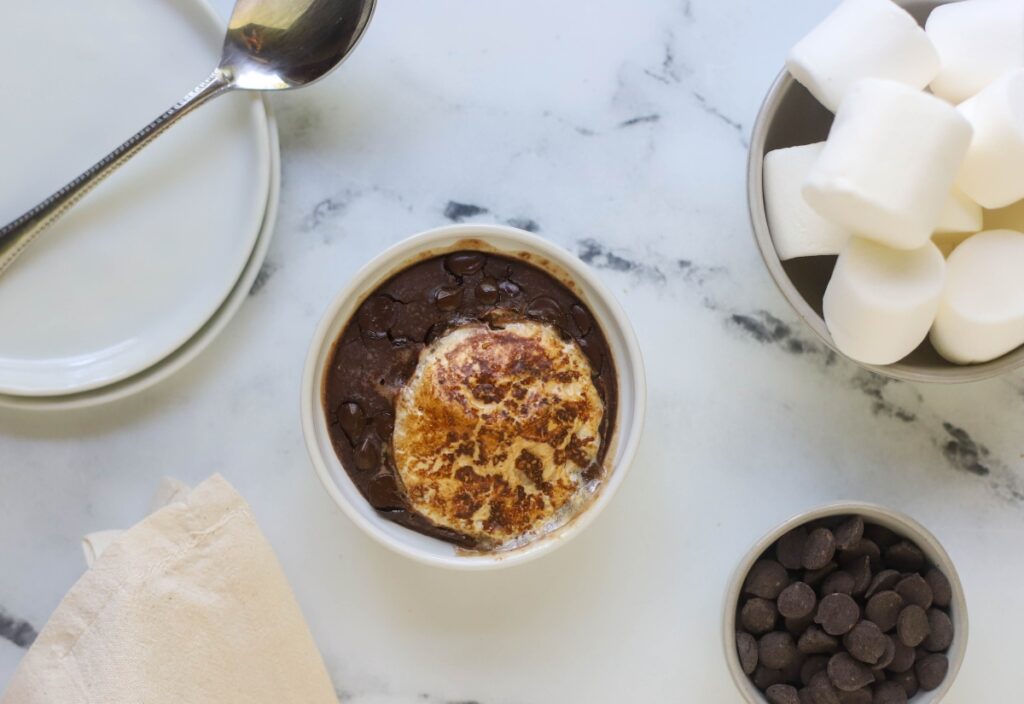 white bowl with baked oats and marshmallow on marble counter