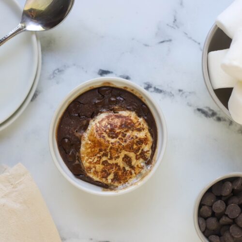 white bowl with baked oats and marshmallow on marble counter