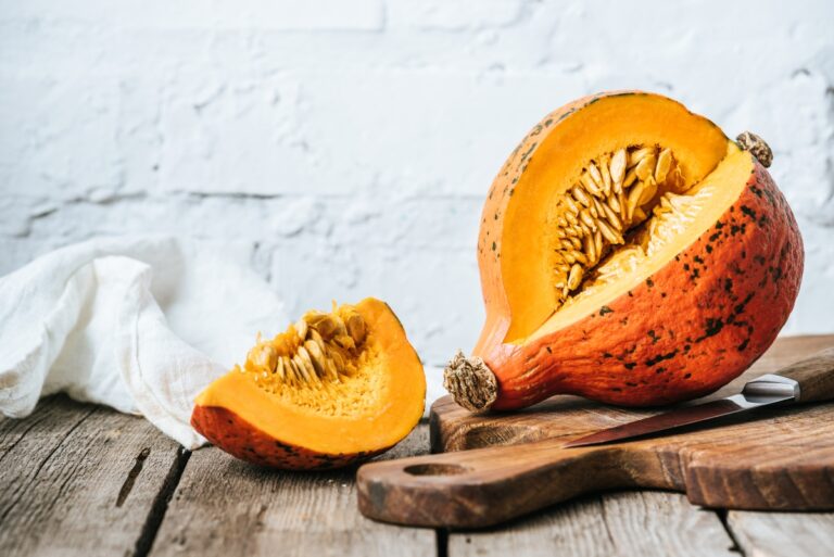 Pumpkin and its slice on cutting board