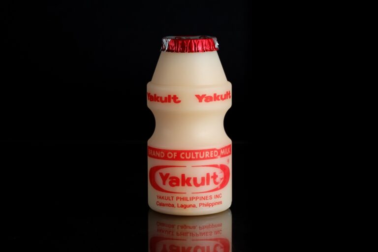 A bottle of yakult against the black background