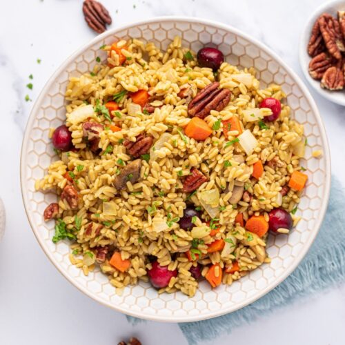 A bowl of Thanksgiving rice with pecans and vegetables