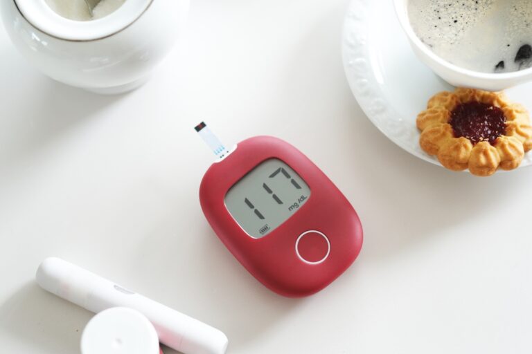 Glucometer and a cup of coffee and a cookie beside