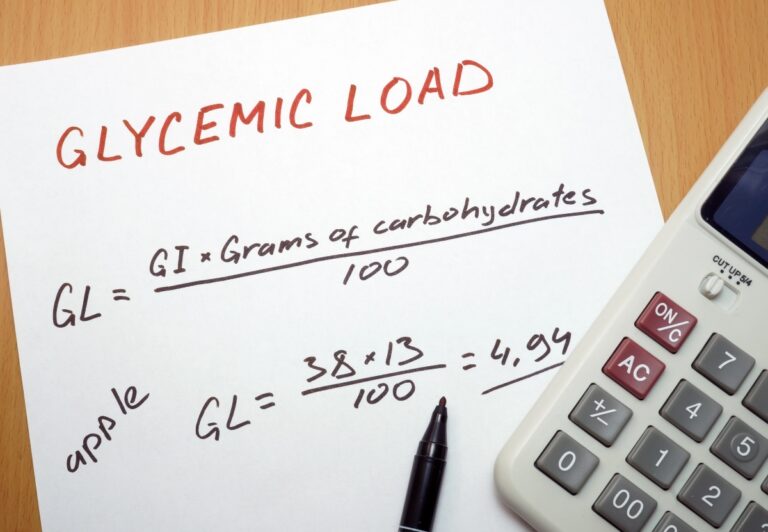 Glycemic load calculation on a paper with a pen and a calculator beside
