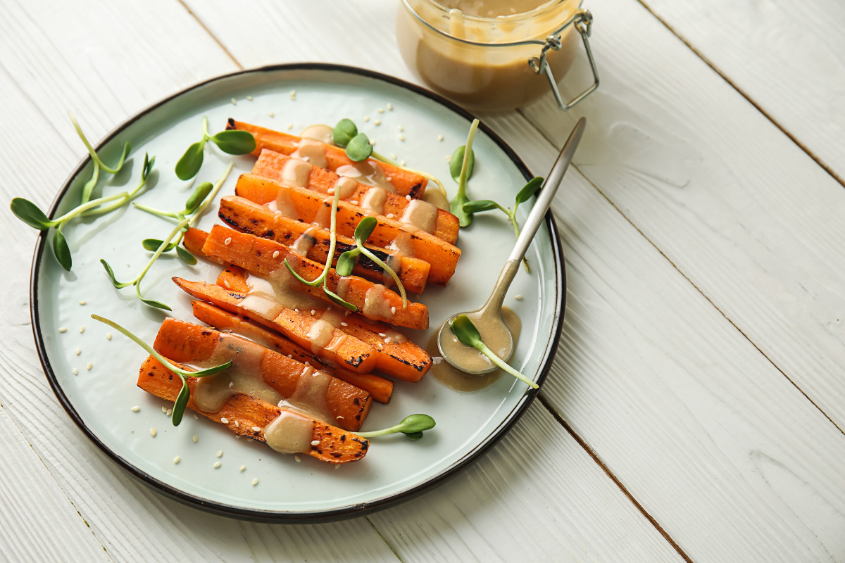 Grilled carrots on a plate with tahini sauce