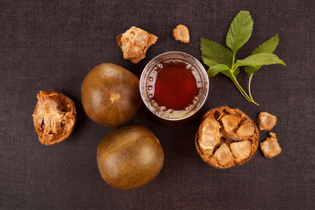 Monk fruit tea in a glass with monk fruits and leaves around