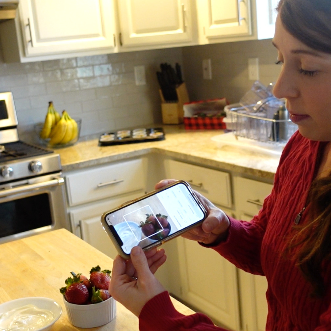 Woman taking picture of the strawberries