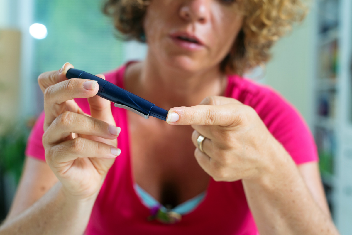 A woman measuring blood sugar with glucose meter