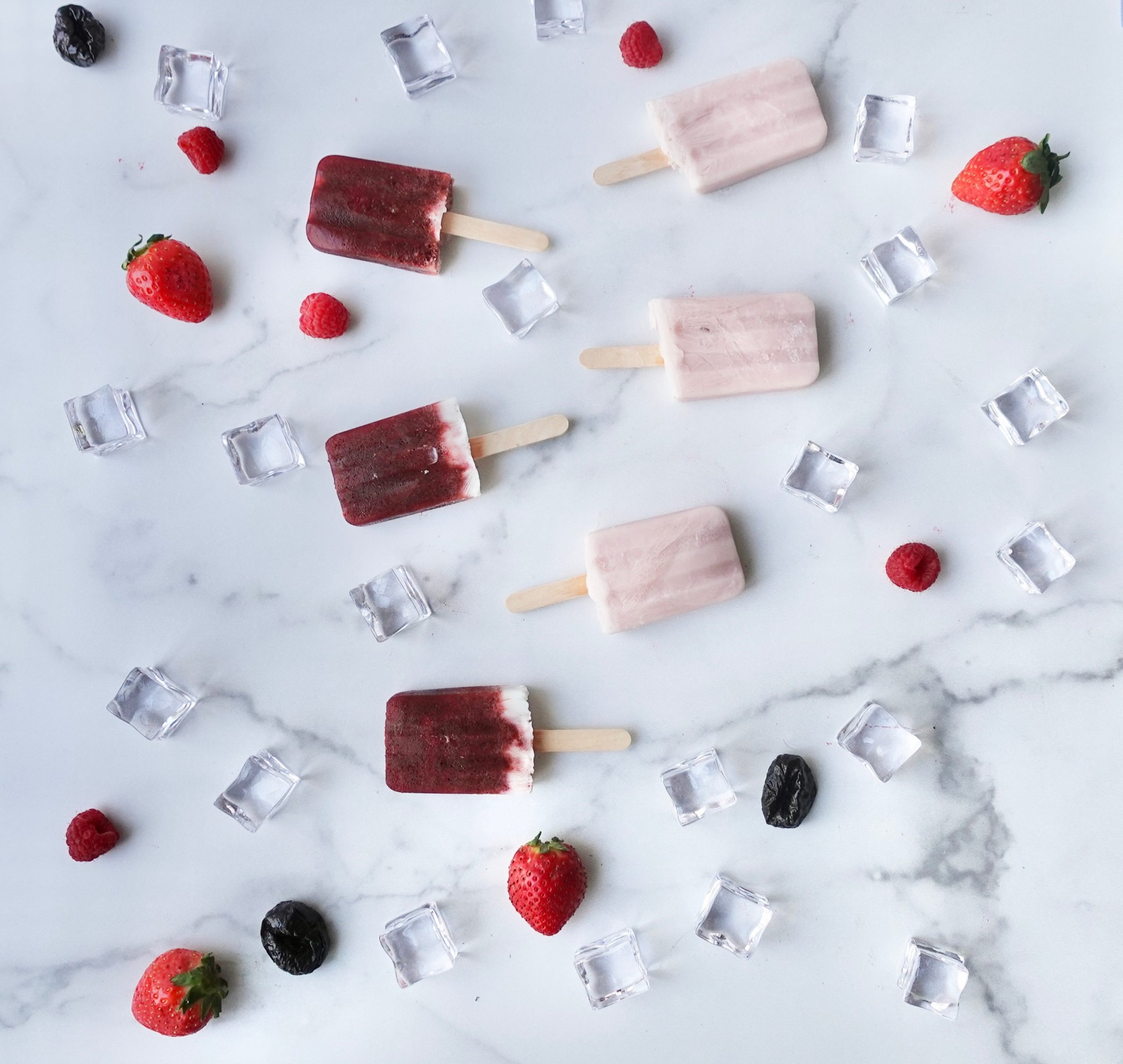 No sugar added popsicles with plum juice with ice cubes and berries