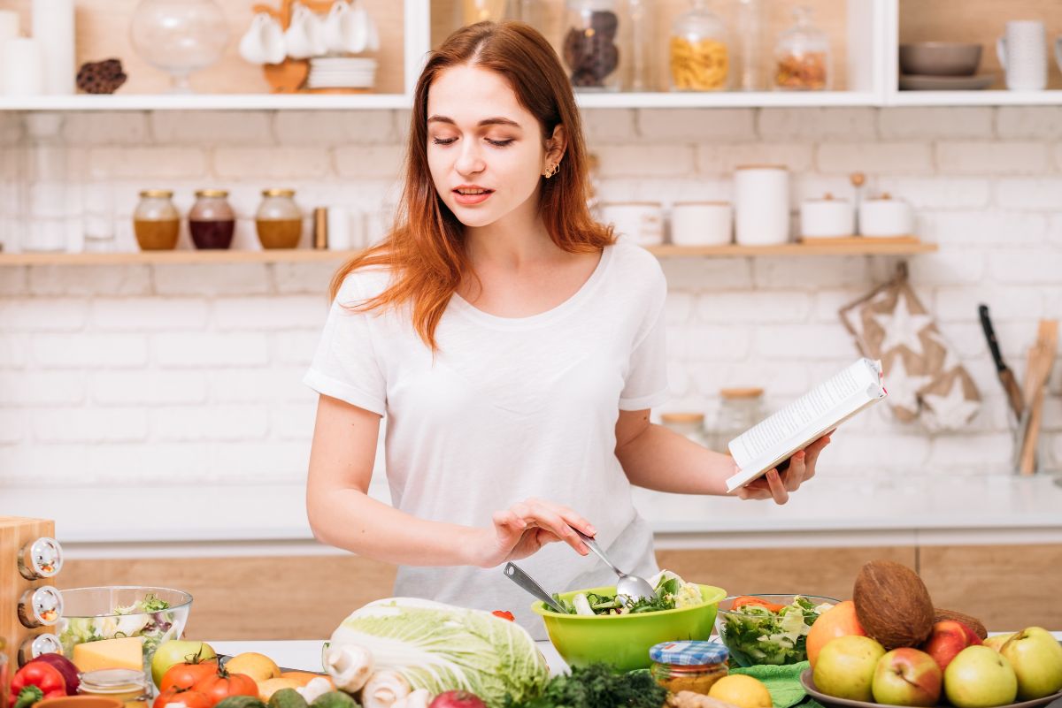 Woman reading a recipe and cooking food with whole foods