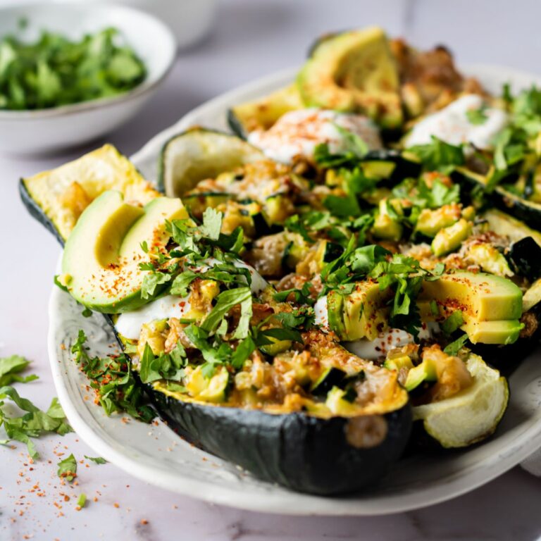 zucchini boats garnished with fresh herbs and sour cream