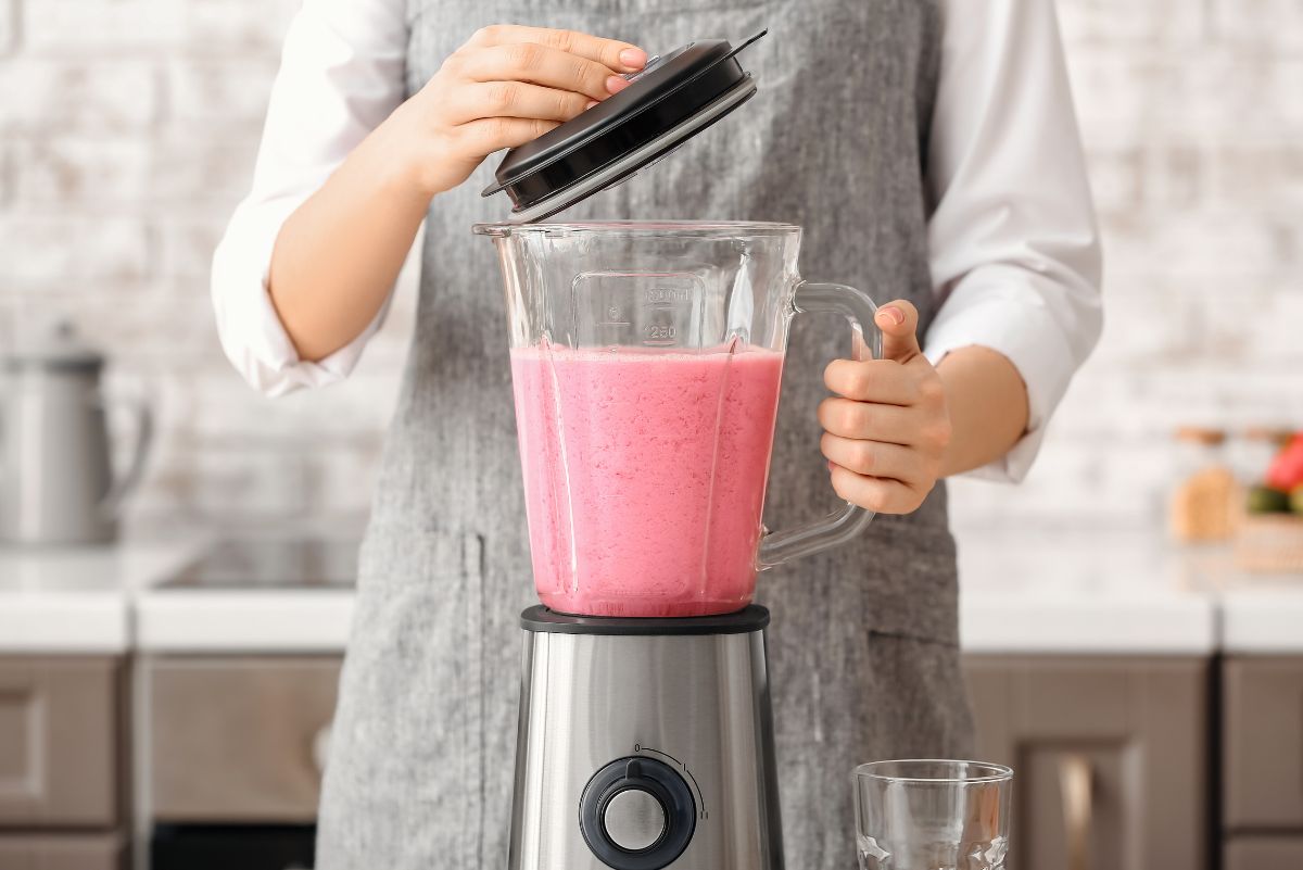 Woman making a smoothie with sea moss and berries