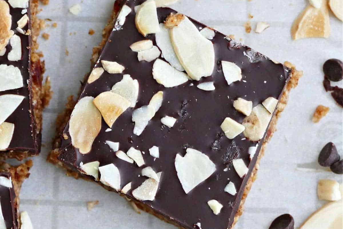 Oatmeal date almond butter bars topped with sliced almonds