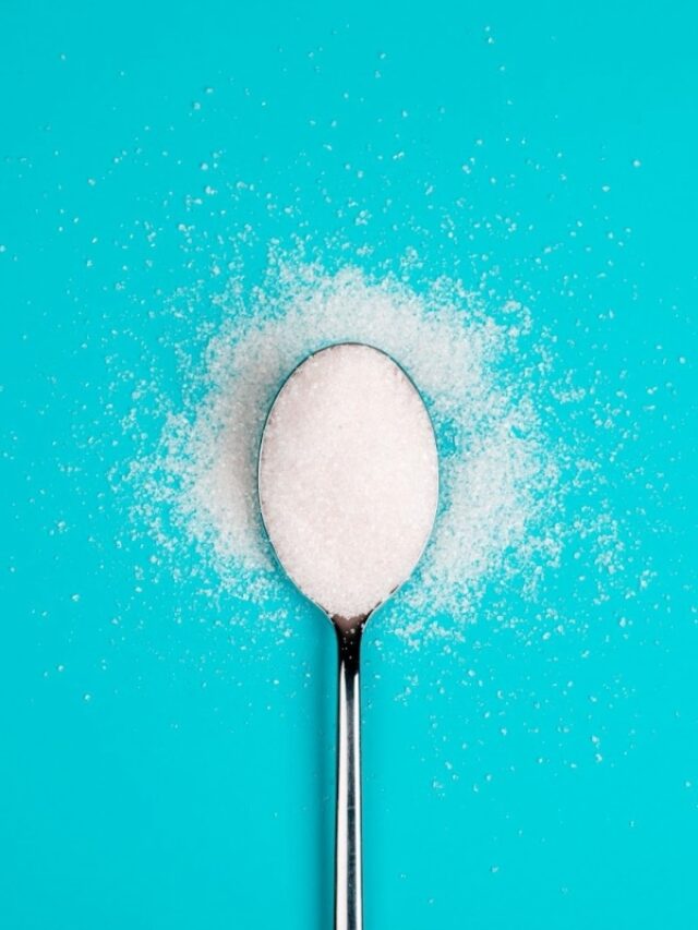 A spoon with sucralose against the blue background