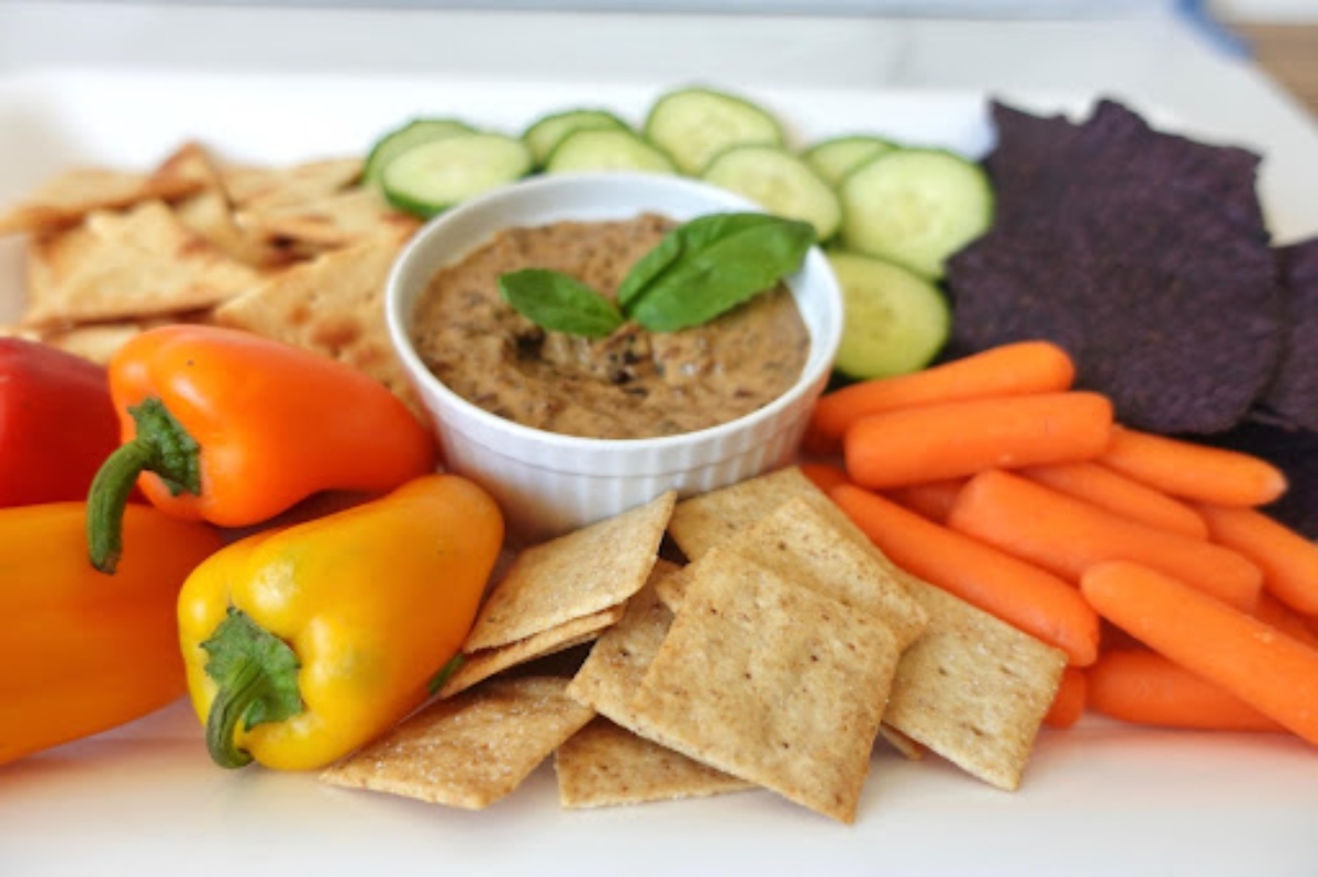Plummus in a cup with veggies and crackers
