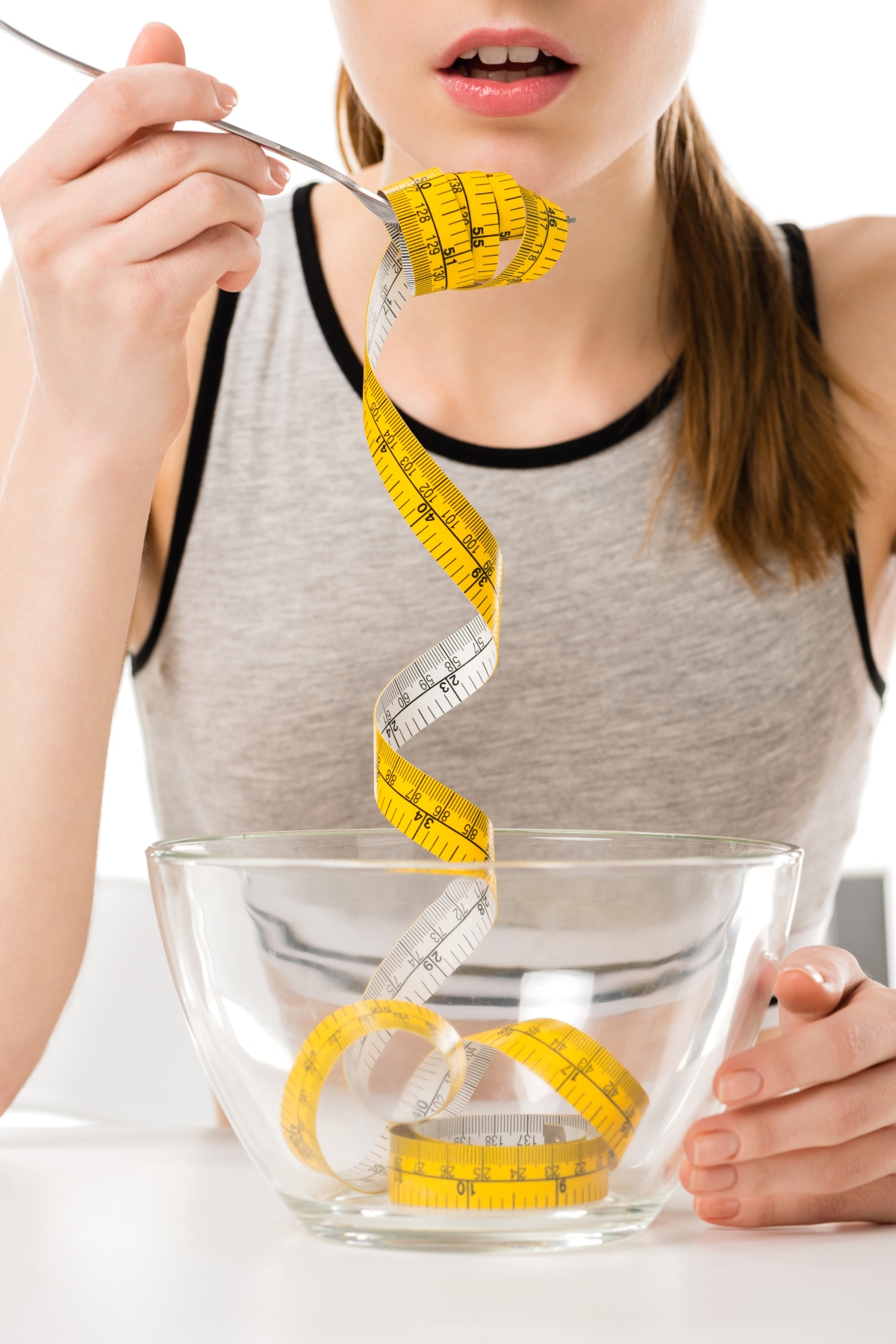 Woman eating measuring tape from a bowl