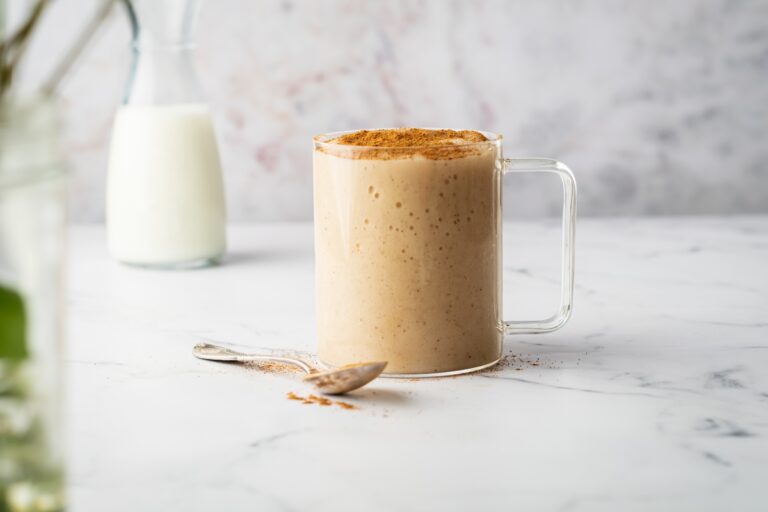 Sea moss drink in a glass mug with a spoon beside