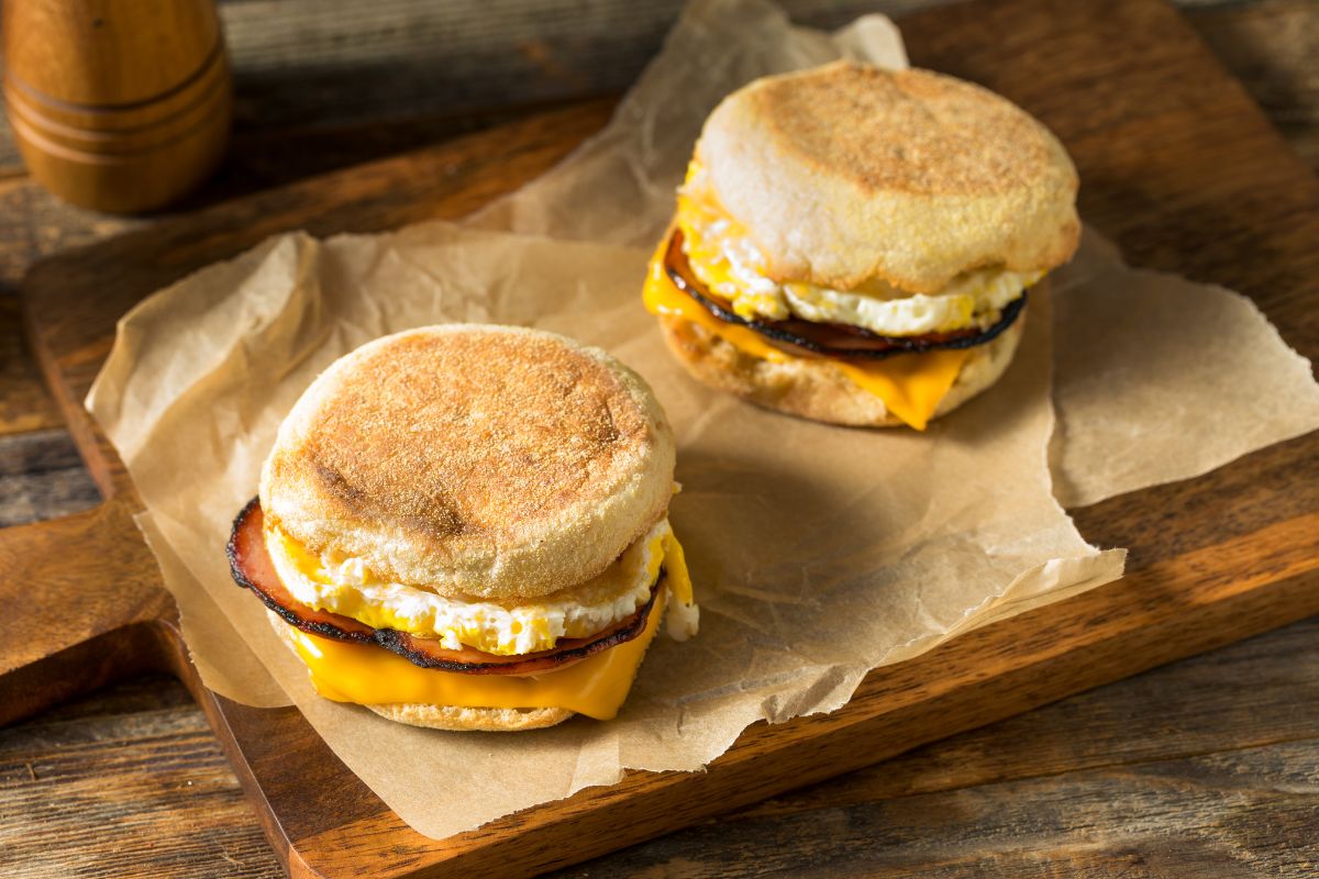 Two Egg McMuffins served on a wooden cutting board