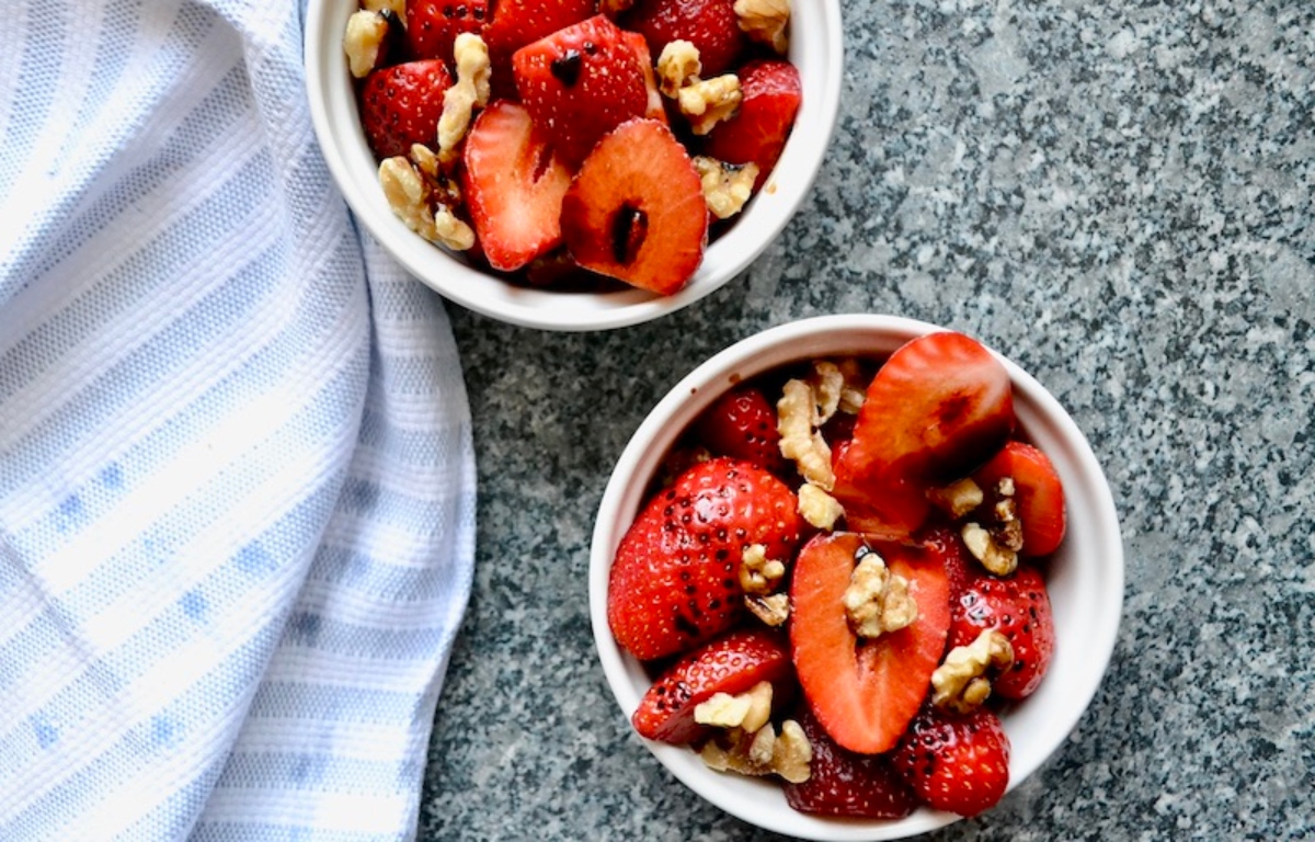 Strawberry with walnuts and balsamic glaze in white bowls
