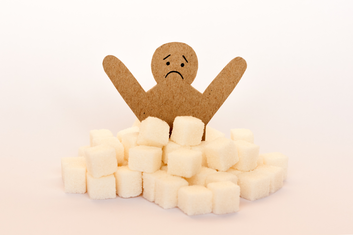 Cardboard man surrounded by refined sugar cubes