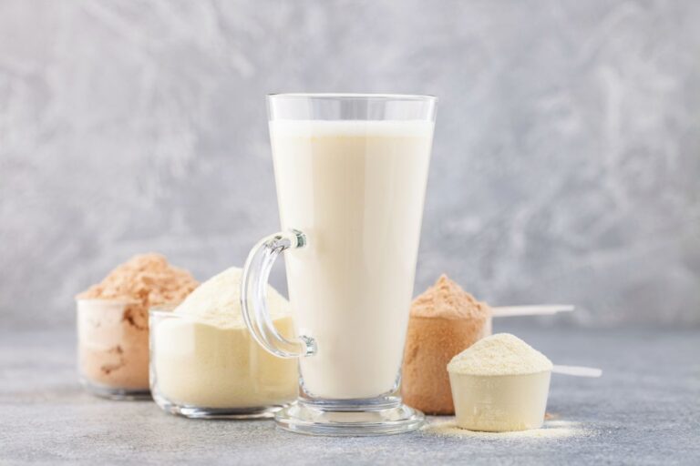 Protein powder and milkshake against the grey background