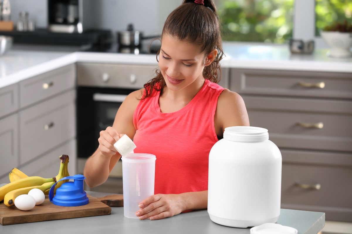 Woman preparing a protein milkshake with protein powder