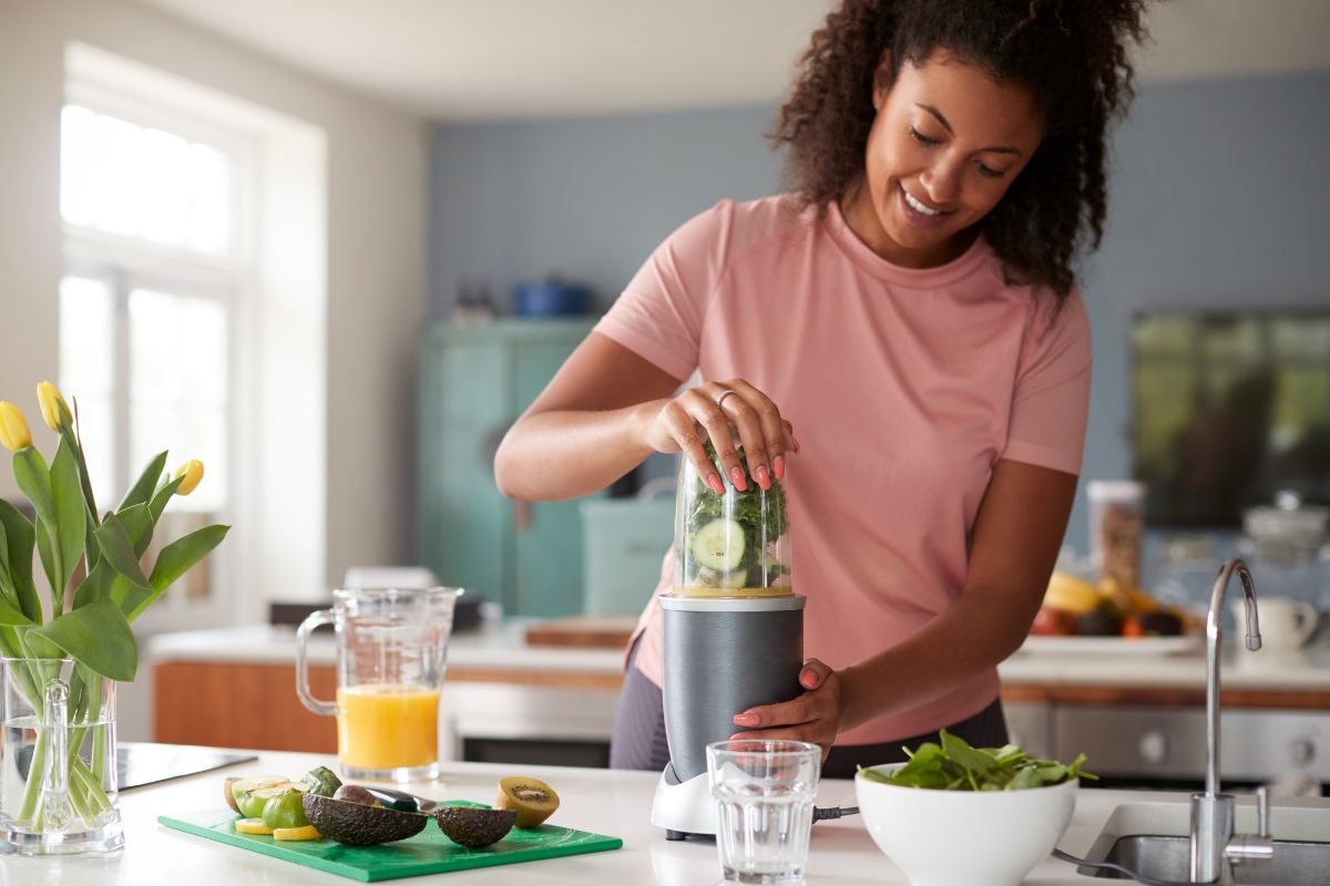 Woman Making Healthy Juice Drink with Fresh Ingredients
