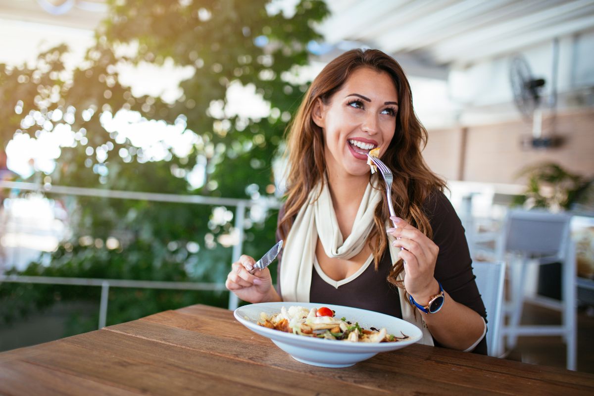 Woman eating fish salad in a restaurant