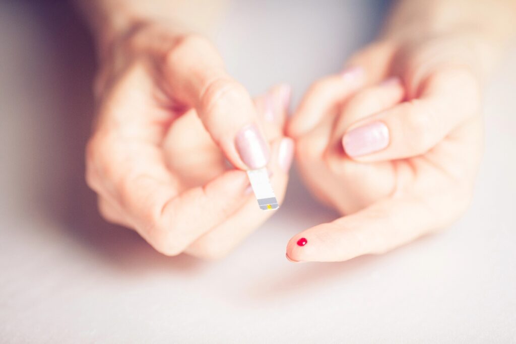 A woman measuring blood sugar levels with blood glucose monitor