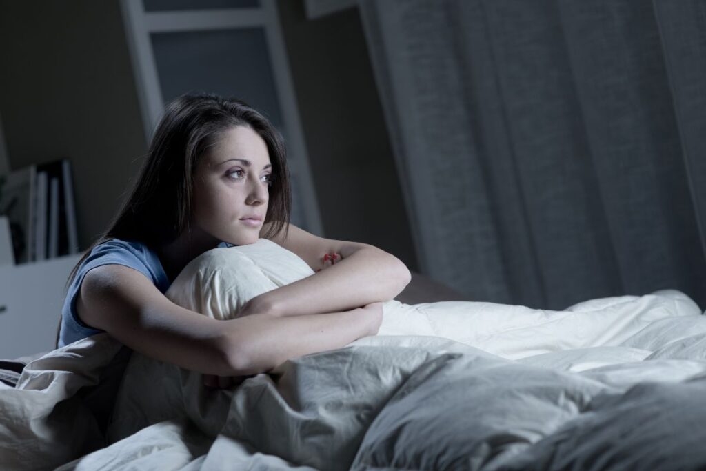 Woman with insomnia sitting in a bed