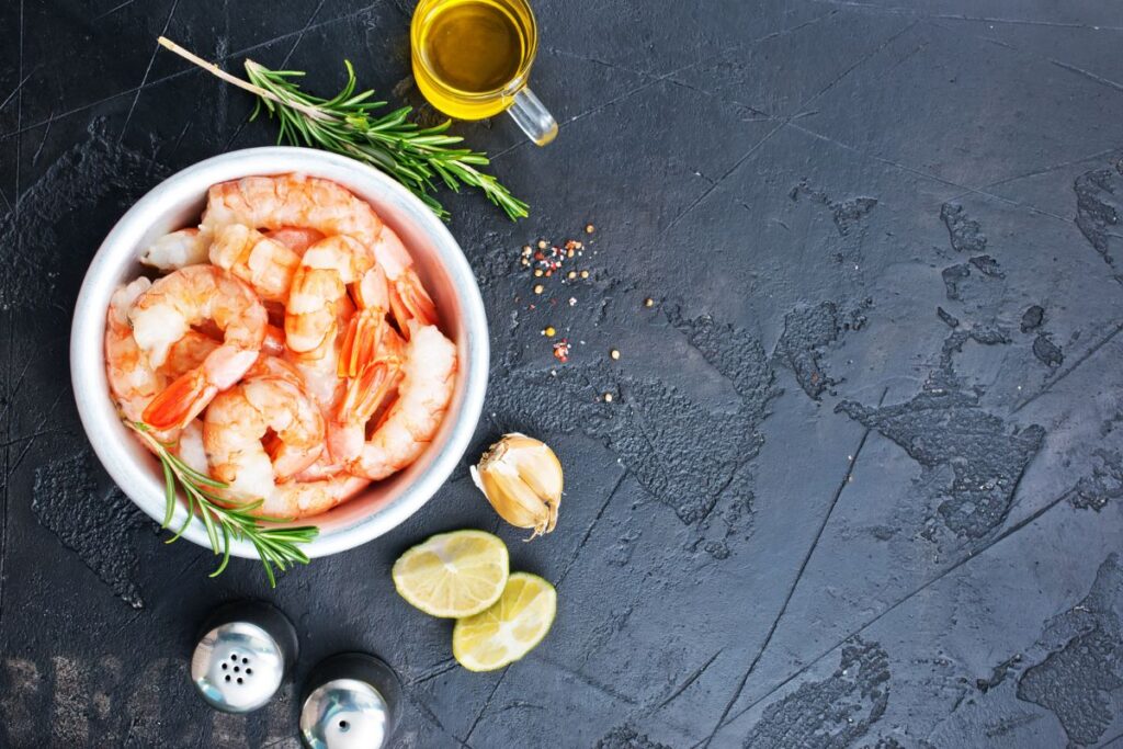 Shrimps in a white bowl on a black surface